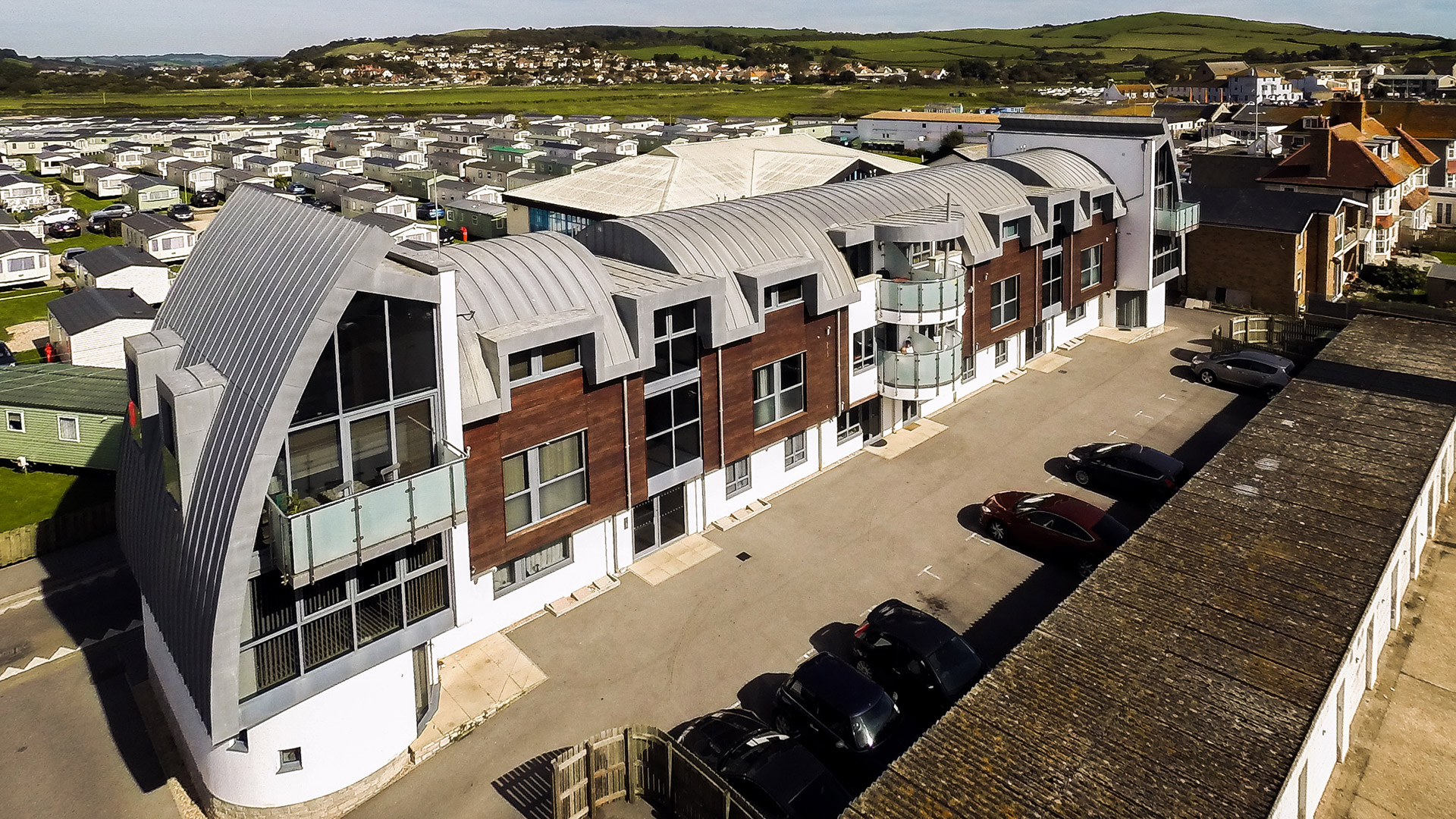 aerial view of curved roof building and car park